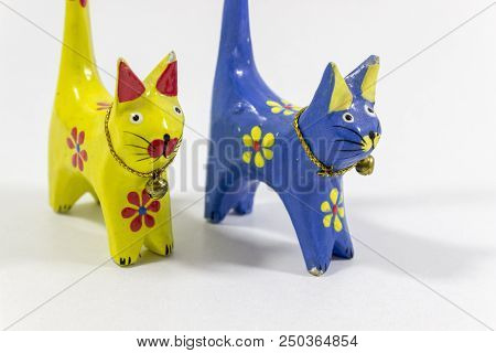 Close-up Shot Of Blue And Yellow Small Cat Figures Of Wooden Carved Nicknack