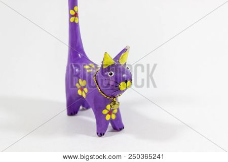 Perspective Close-up Shot Of Purple Cat Figure Wooden Carved Nicknack