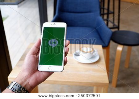 A Man Sit In Cafe Holding Mobile With Line Screen