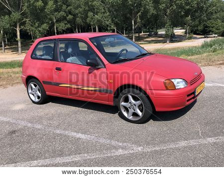 Almere, The Netherlands - July 21, 2018: Pale Red Toyota Starlet Parked At A Public Parking Lot. Nob