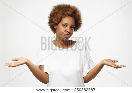 I Don't Know. Young Afrcian American Woman Isolated On Grey Background, Showing Helpless Gesture Wit