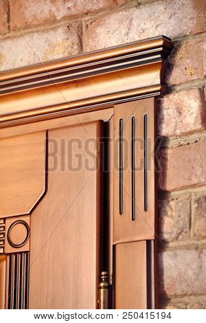 Element Of A Wooden Door Brown Colored Carved In Classical Geometric Style With Golden Hinges On Bri