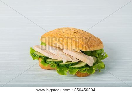 Pressed And Toasted Double Panini With Ham And Cheese Served On Sandwich Paper On A Wooden Table