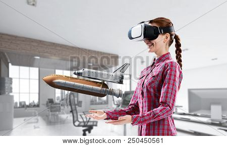 Young Caucasian Woman In Modern Office Interior Trying Virtual Reality Helmet And Viewing Space Shut