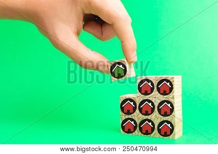 The Businessman's Hand And Wooden Cubes With Houses. Investment In Real Estate. Buildin, Sale, Rent,