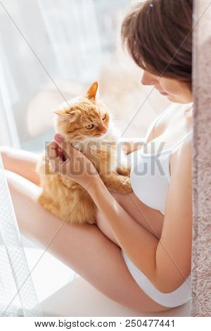 Pregnant Woman In White Underwear With Cute Ginger Cat. Young Woman Expecting A Baby. Risk Of Infect