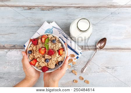 Young Woman With Bowl Of Tasty Corn-flakes With Healthy Berries From Above. Delecious Breakfast.
