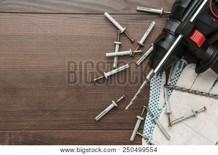 Hammer Drill And Dowels On The Wooden Background With Copy Space
