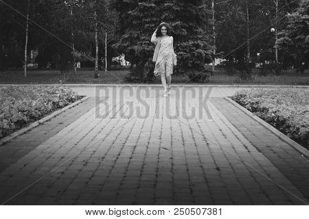 A Beautiful Girl In A Hat, Keeps The Hair From The Wind. Sits On Scraps. Walk Around The City. Portr