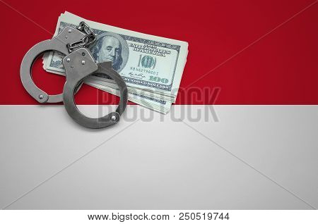 Indonesia Flag  With Handcuffs And A Bundle Of Dollars. The Concept Of Breaking The Law And Thieves 