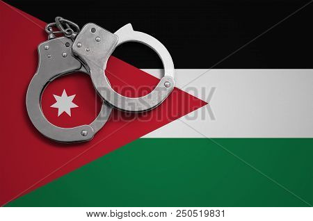 Jordan Flag  And Police Handcuffs. The Concept Of Crime And Offenses In The Country.