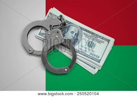 Madagascar Flag  With Handcuffs And A Bundle Of Dollars. Currency Corruption In The Country. Financi