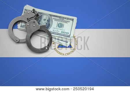 Nicaragua Flag  With Handcuffs And A Bundle Of Dollars. The Concept Of Breaking The Law And Thieves 