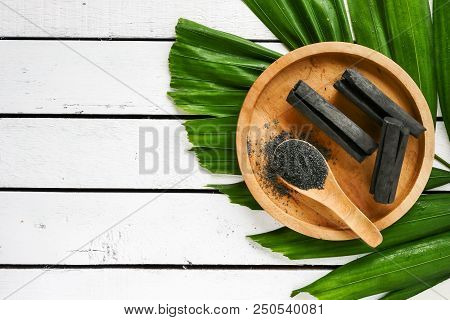 Bamboo Charcoal And Powder On Wooden Table. Copy Space