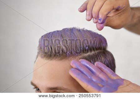 Barber's Hand Toning Young Client's Hair In Violer Color.