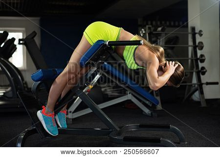 Sports Young Woman Doing Exercises On Trainer Back Machine In The Gym, Doing Hyperextension