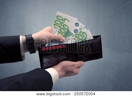 Businessman's hand in suit takes out eruo from his wallet