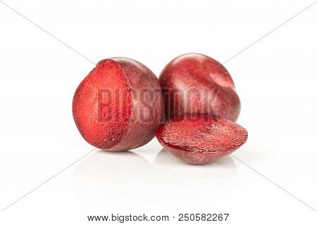 Group Of One Whole Two Halves Of Fresh Pluot Interspecific Plums Variety Isolated On White