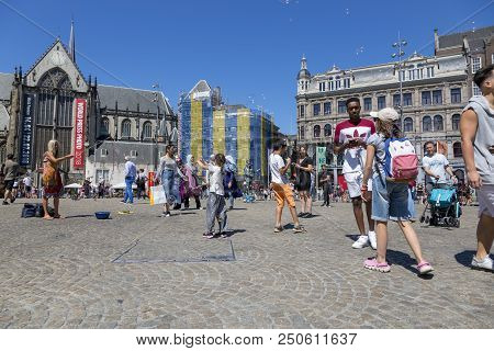 Amsterdam, Netherlands - July 02, 2018: Children Catch Soap Bubbles In The Central Dam Square In Ams