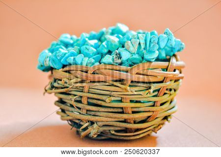Pile Stones Of Raw Turquoise In Small Wooden Nest On A Brown Background. Blue And Green Color Stones