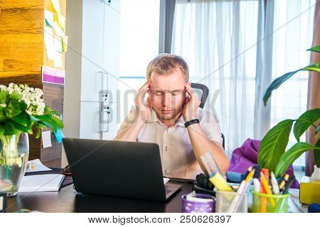 Feeling Tired And Depressed. Frustrated Young Man Entrepreneur Holding Head In Hands While Sitting O