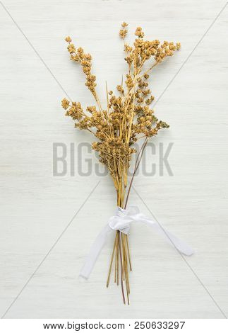 Beautiful Autumnal Easter Wedding Background. Dry Wild Flowers Tied With Silk Ribbon On White Wood. 