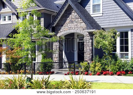 Beautiful new contempory suburban houses with colorful summer gardens in a Canadian neighborhood.