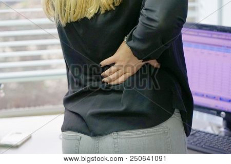 Close-up View Of A Office Worker Woman With Pain In Kidneys. Young Woman With Back Ache Clasping Her