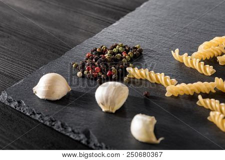 vermicelli Garlick fennel pepper of basilic on a black stone background