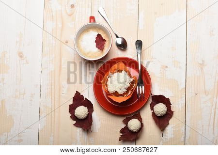 Cup Of Cappuccino Coffee On Wooden Background With Autumn Leaves, Coconut Balls Sweets And Cupcake. 