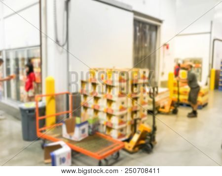 Worker With Manual Forklift Stockpile Goods Near Cold Storage Room In Wholesale Store