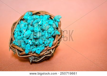 Pile Stones Of Raw Turquoise In Small Wooden Nest On A Brown Background. Blue And Green Color Stones