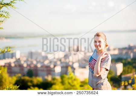 Portrait Of A Woman In An American T-shirt On The Background Of Saratov, Russia, View Of The Houses,