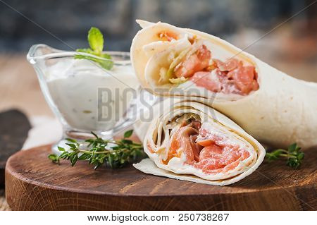 Fresh Tortilla Wrap With Vegetables And Salmon On Wooden Cutting Board