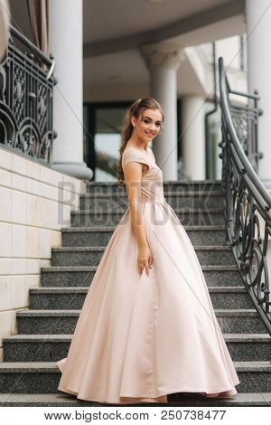 Elegant Lady Satnd On Stairs In Front Of Restaurant.