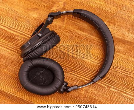 Headphones On Wooden Desk Table. Music Concept. Top View