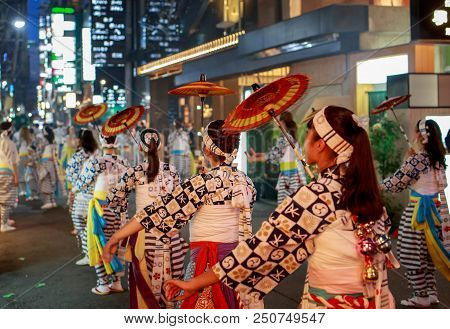 Osaka, Japan - July 23, 2018: Young Women With Red Paper Umbrellas Perform Traditional Dance In Stre