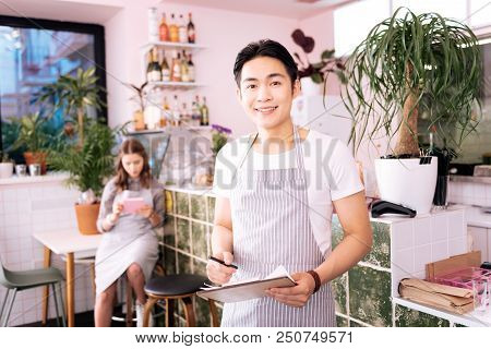 Nice Bar. Dark-eyed Young Man Having Day Shift While Working Really Hard In Nice Fancy City Bar