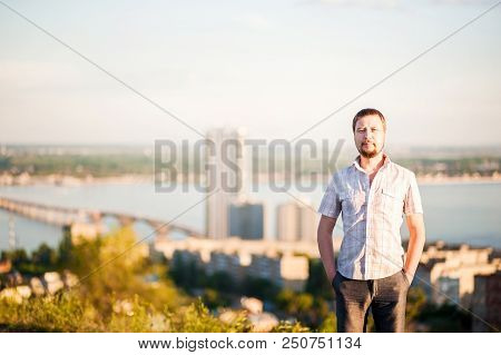 Portrait Of A Man In The Background Of Saratov, Russia, View Of The Houses, The Volga River, The Bri