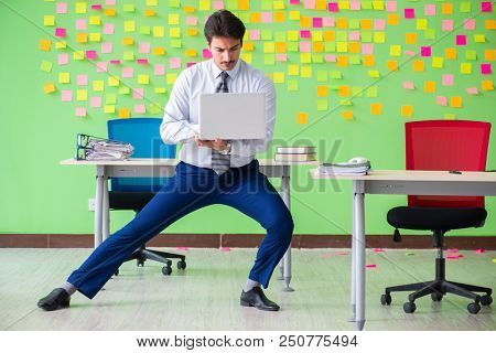Man in the office with many conflicting priorities doing exercis