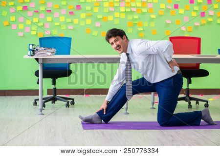 Man in the office with many conflicting priorities doing exercis