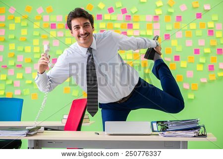 Man in the office with many conflicting priorities doing exercis