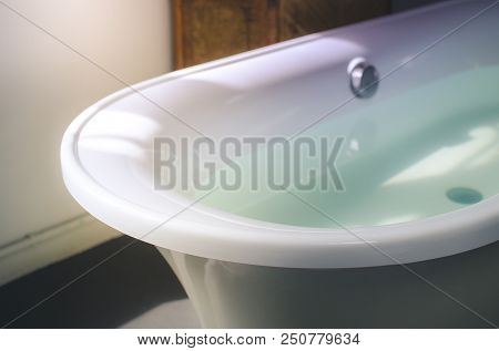 White Empty Bathtub In The Morning Light. Close Up And Selective Focus.