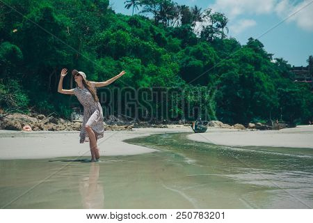 Beautiful Girl Dancing On The Beach. Portrait Of A Woman In White Clothes On The Sea. Dancer On The 