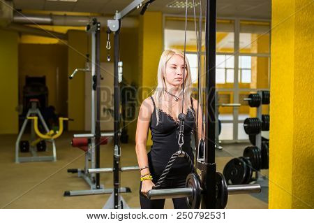 Sport, Fitness, Lifestyle And People Concept - Close Up Of Young Woman Flexing Muscles On Cable Gym 