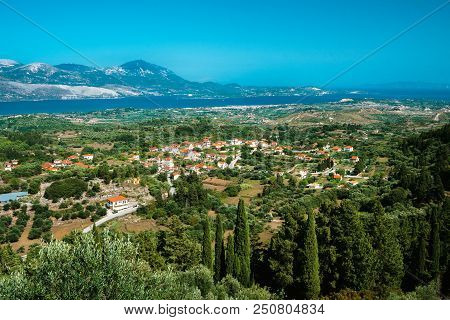 View Of Idyllic Valley Town With Red Roofs On Mediterranean Island. Olive Groves, Cypresses And Blue