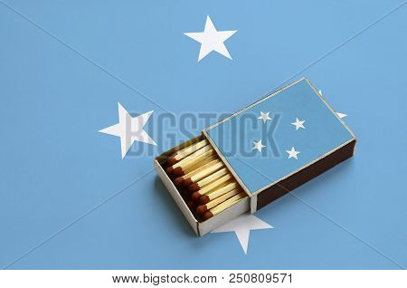 Micronesia Flag  Is Shown In An Open Matchbox, Which Is Filled With Matches And Lies On A Large Flag