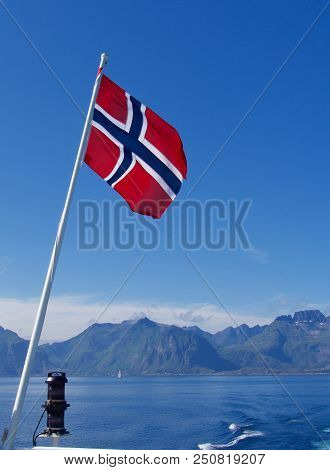 Flag Of Norway On The Blue Sky And Mountainds Background.