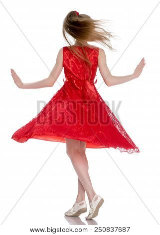 Beautiful Little Girl In A Dress Is Spinning. Concept Of Happy Childhood, Dancing, Holidays. Isolate