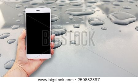 Mockup Image Of Hands Holding White Mobile Phone With Water Drops Background